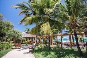 A tropical resort with a gazebo, palm trees, and a beach view. - La Torre Resort All Inclusive (Porto Seguro)