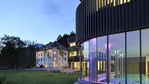 Un bâtiment moderne doté de grandes fenêtres en verre et d’un espace piscine.