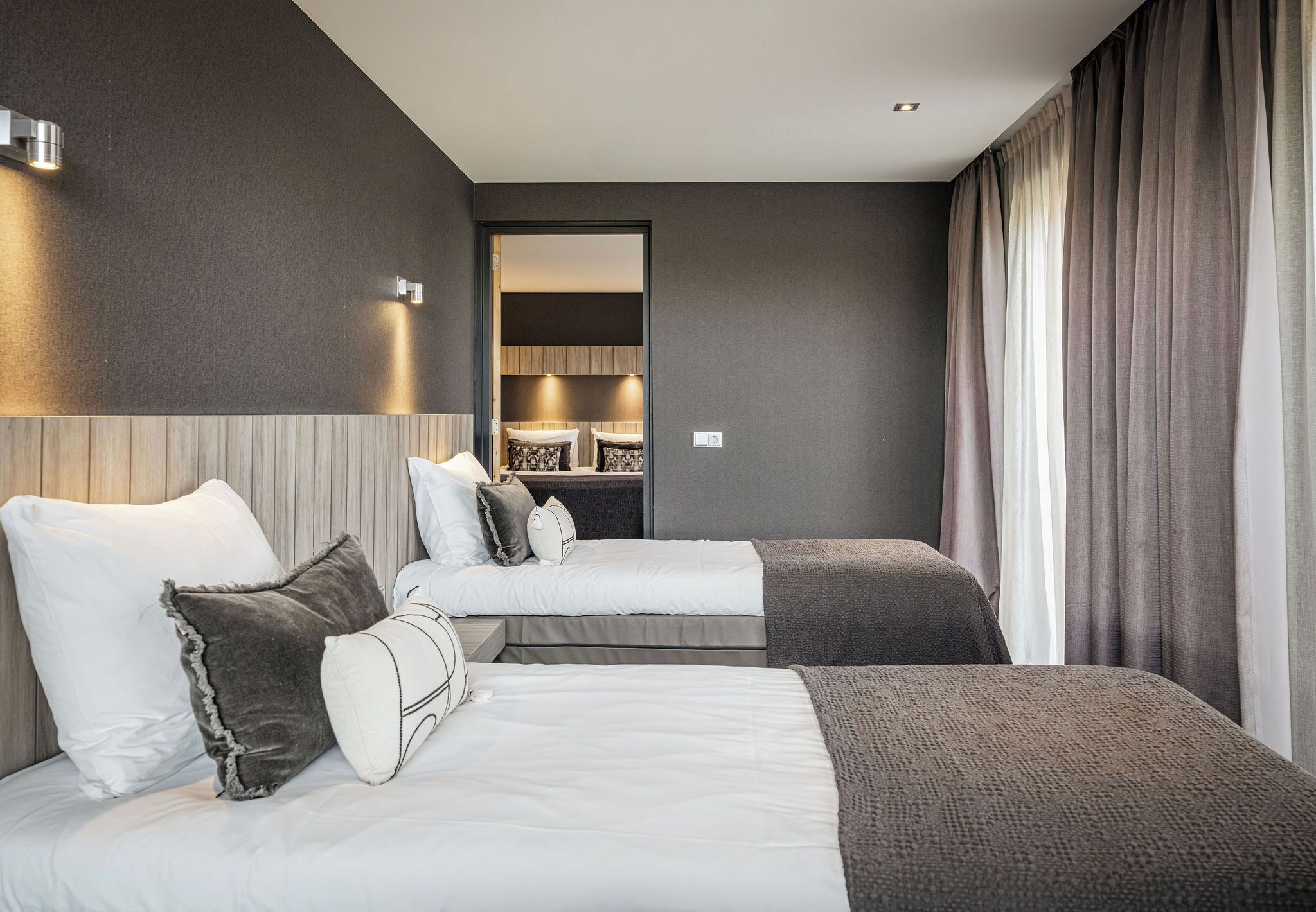 Habitación de hotel con dos camas, un armario y un espejo.