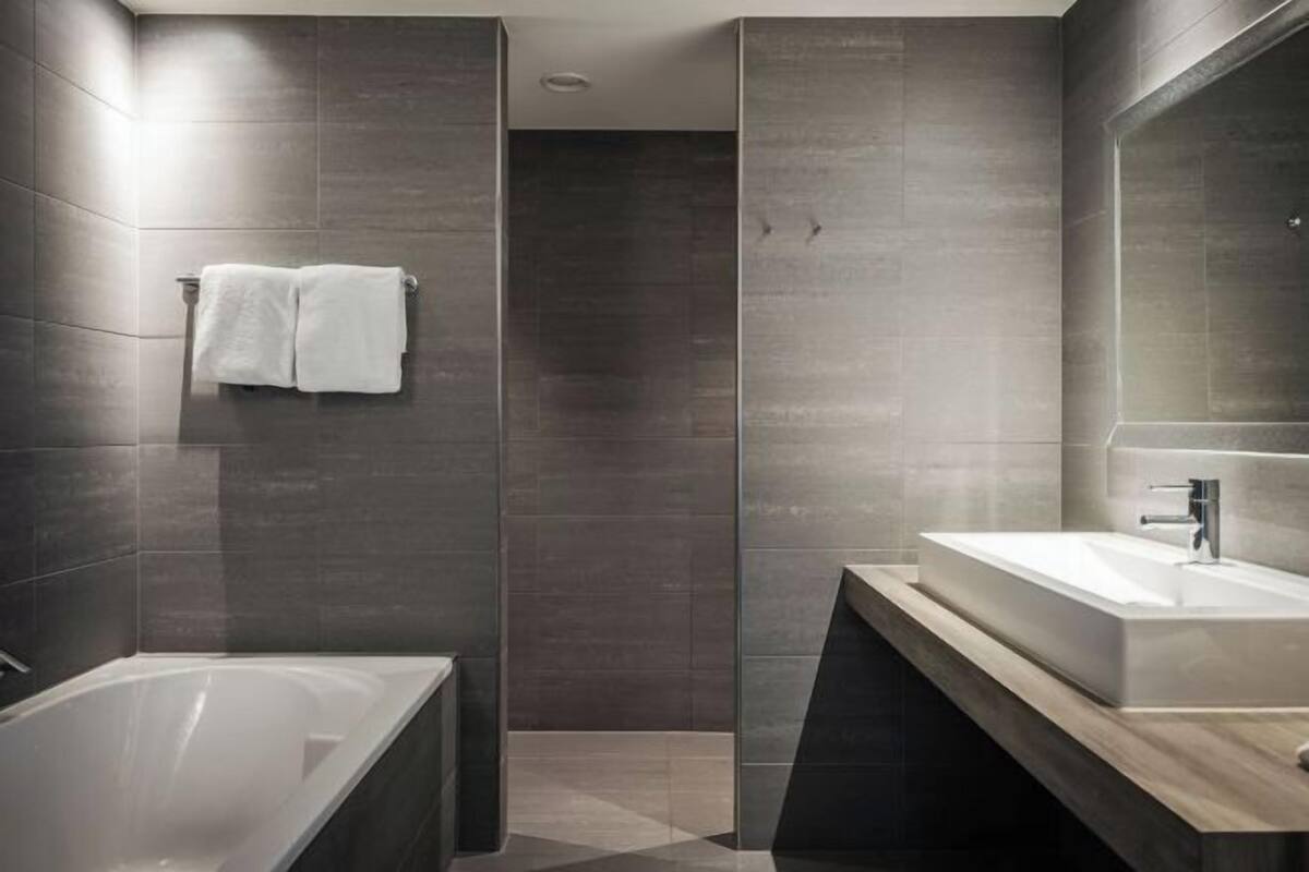 Badkamer | Een aparte badkuip en douche, gratis toiletartikelen, een haardroger