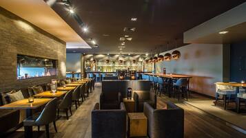 Un restaurante moderno con barra, mesas de madera y asientos cómodos.