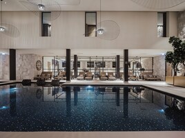Una piscina techada, sillones reclinables de piscina