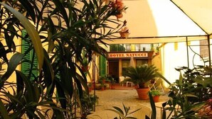 L’entrée d’un hôtel, avec une enseigne indiquant « HÔTEL NATUCCI ».