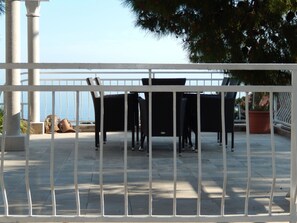 An outdoor patio with a white railing, a table, and chairs. - Dubrovnik Apartments Kovacec (Dubrovnik)
