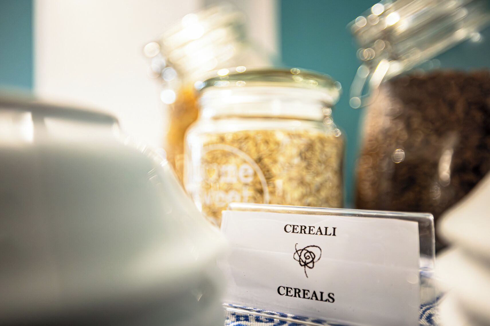 Un présentoir de céréales avec des bocaux et une pancarte indiquant « CEREALI CEREALS ».