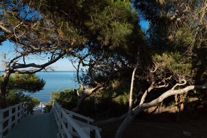 Una escalera de madera que conduce a un mirador con vistas al mar.