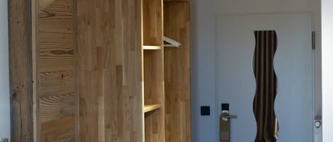 A modern interior with wooden paneling, a bench, and a door with a unique design.