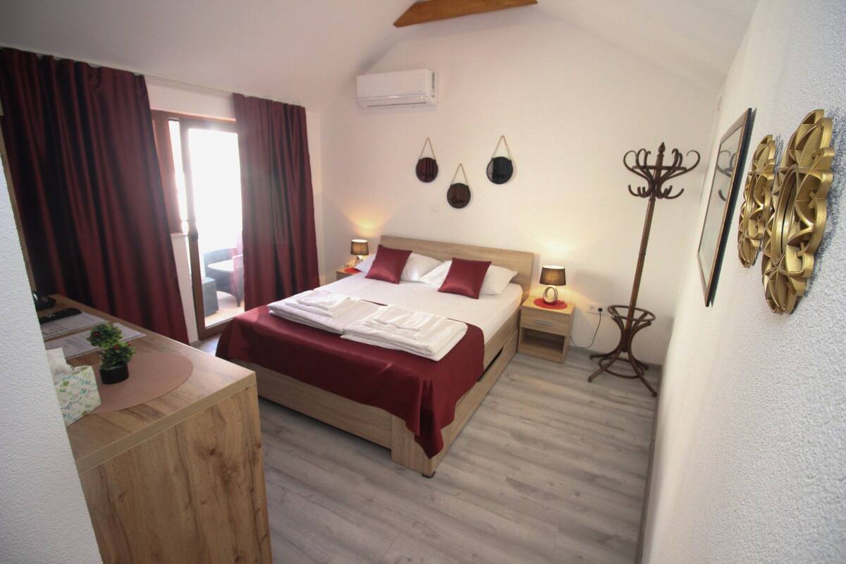 Un dormitorio ordenado con cama, mesitas de noche, un escritorio y una silla.