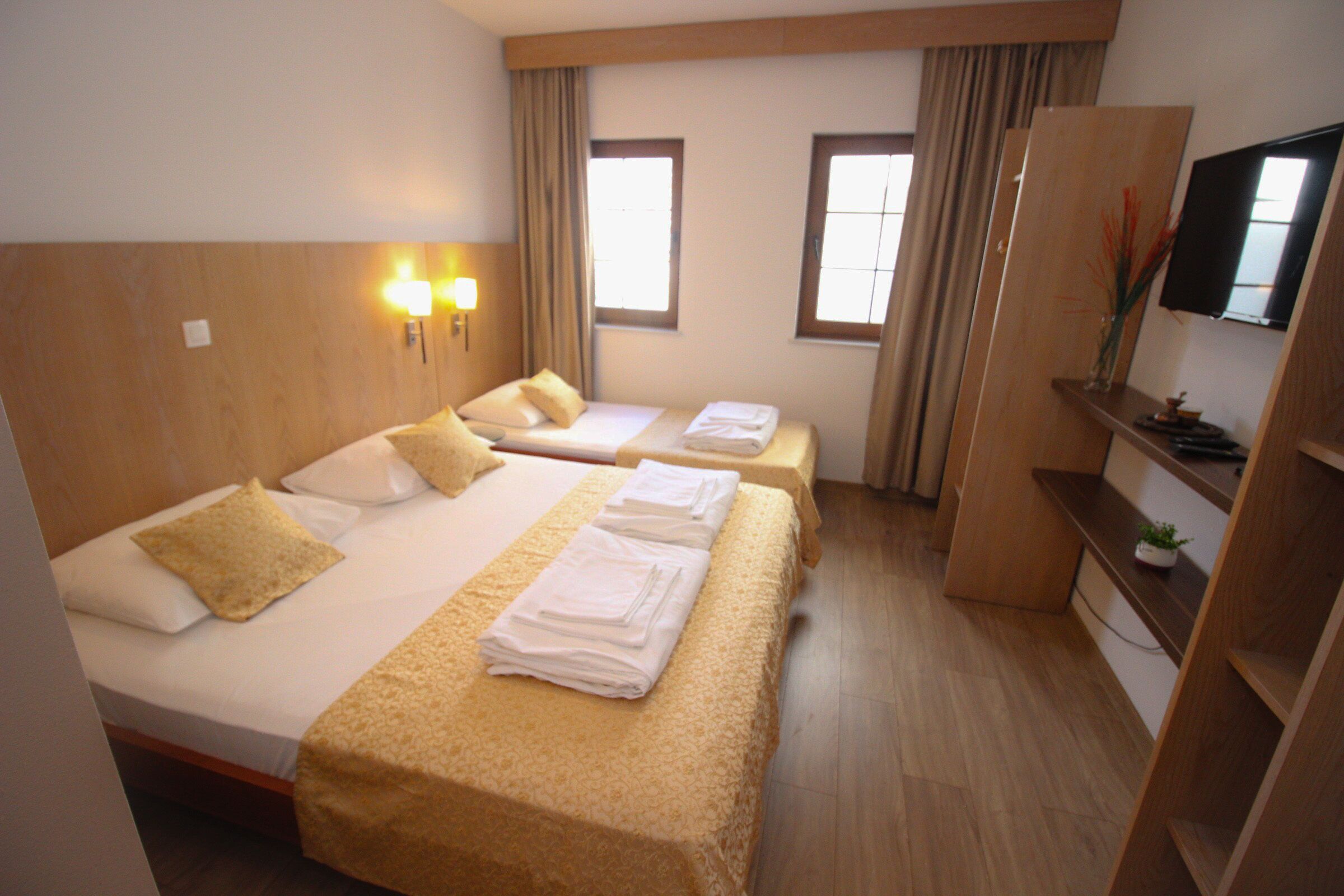 Une chambre d’hôtel avec deux lits, une télévision et un bureau.