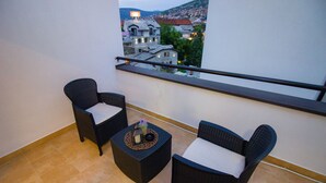 A balcony with two wicker chairs and a small table, featuring a city view. - "VILLA DENY" Boutique HOTEL - with free parking (Mostar)