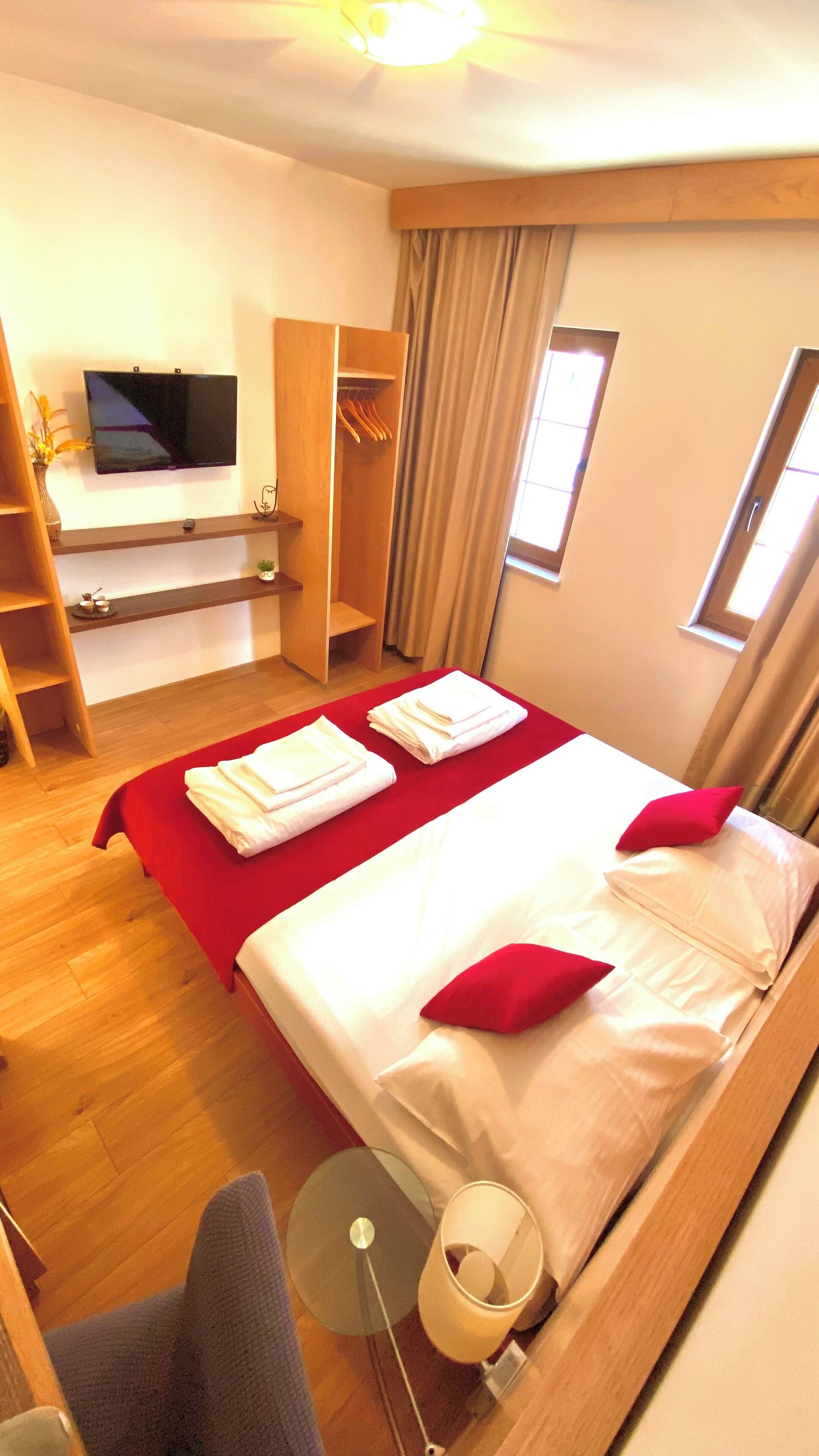 Une chambre d’hôtel équipée d’un lit, d’une télévision, d’une armoire, d’un bureau et d’une fenêtre.
