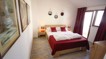 A neatly arranged bedroom with a bed, bedside tables, and wall-mounted decor.