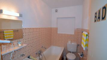 Ein Badezimmer mit Badewanne, Toilette und Waschbecken.