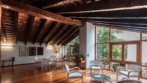 A spacious room with wooden flooring, large windows, and modern furniture. - Hotel Nou Romà (Denia)