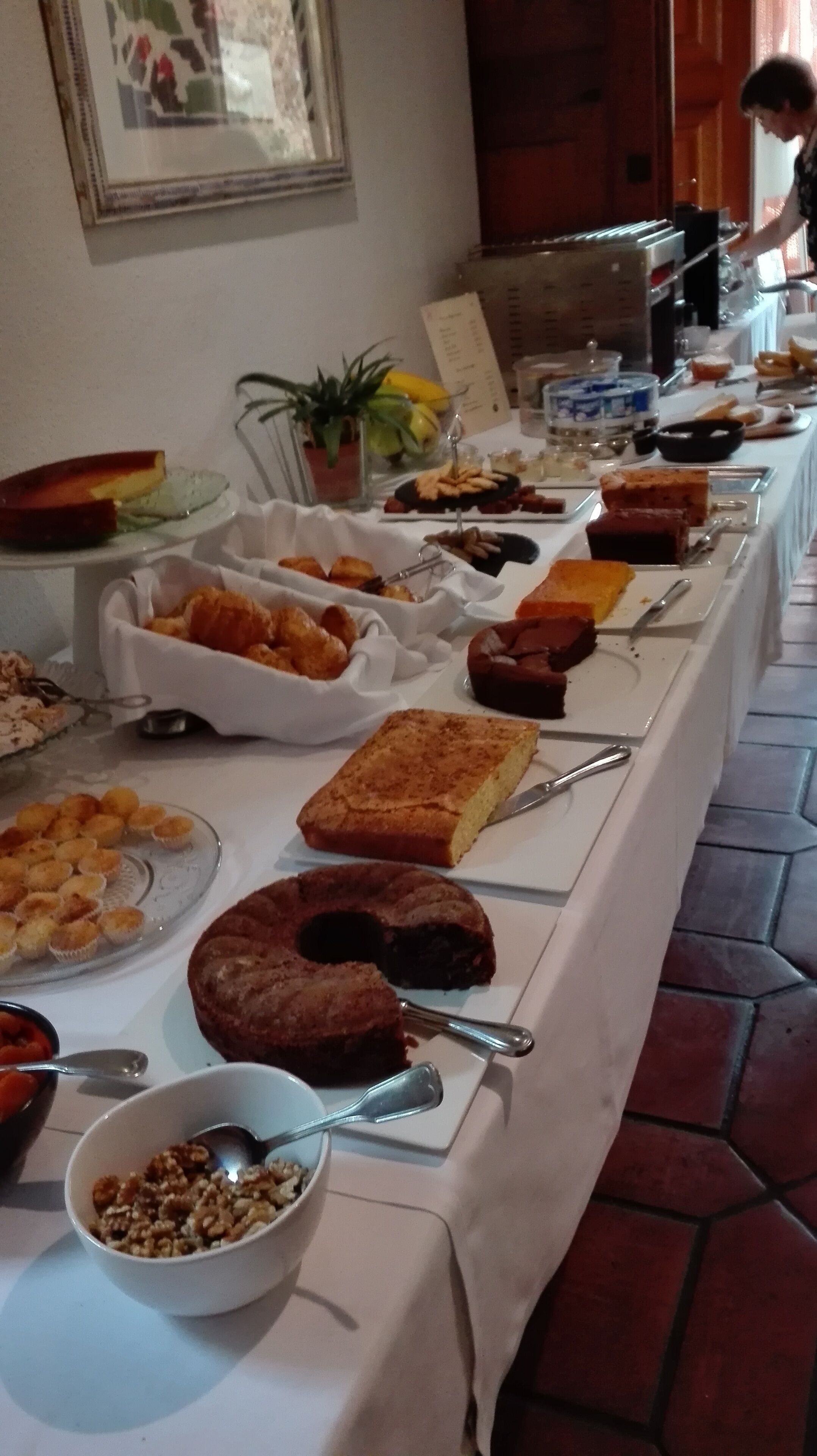 Una mesa de buffet con diferentes alimentos y una persona sirviendo.