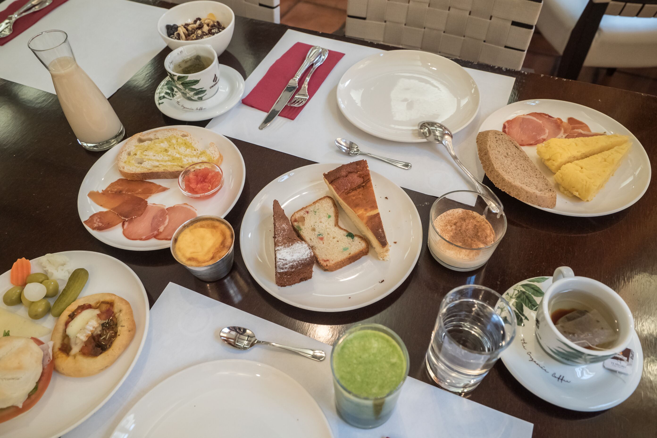 Ein Esstisch mit verschiedenen Speisen, darunter Toast, Eier, Schinken und eine grüne Soße.
