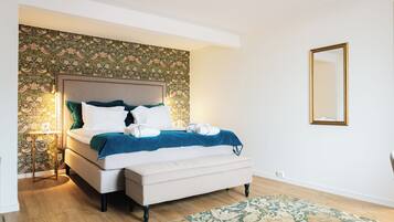 A bedroom with a bed, bedside table, and a mirror.