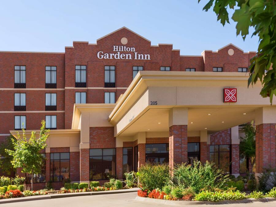 A Hilton Garden Inn with a brick facade, multiple windows, and a landscaped entrance area.