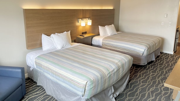A hotel room with two beds, a nightstand, and a desk. - Dunes Motel Hillsboro (Hillsboro)