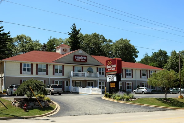 A two-story motel with a red roof and a signboard.