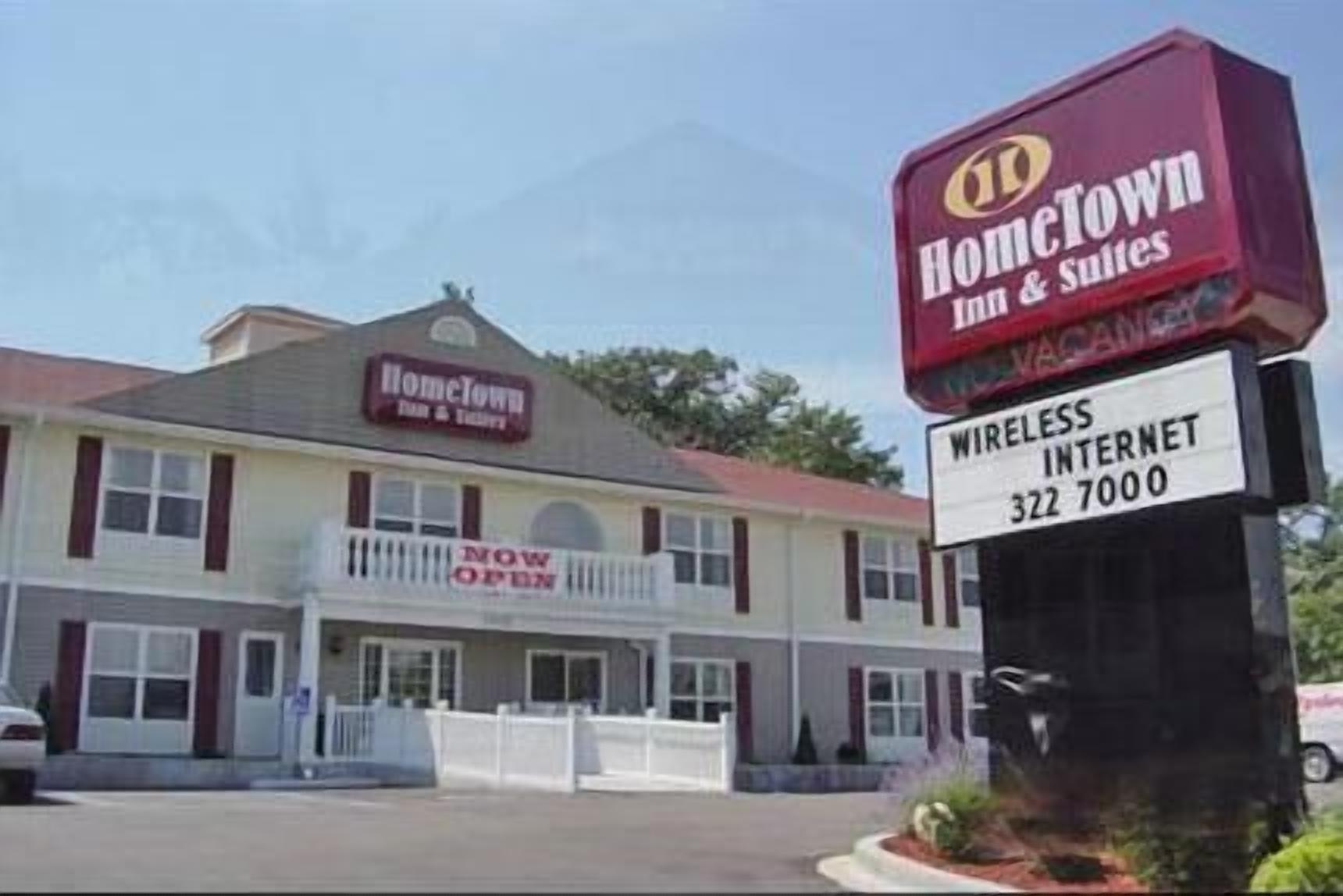 Un edificio con un letrero que dice "HomeTown Inn & Suites" y otro letrero que indica "INTERNET INALÁMBRICO 322 7000".