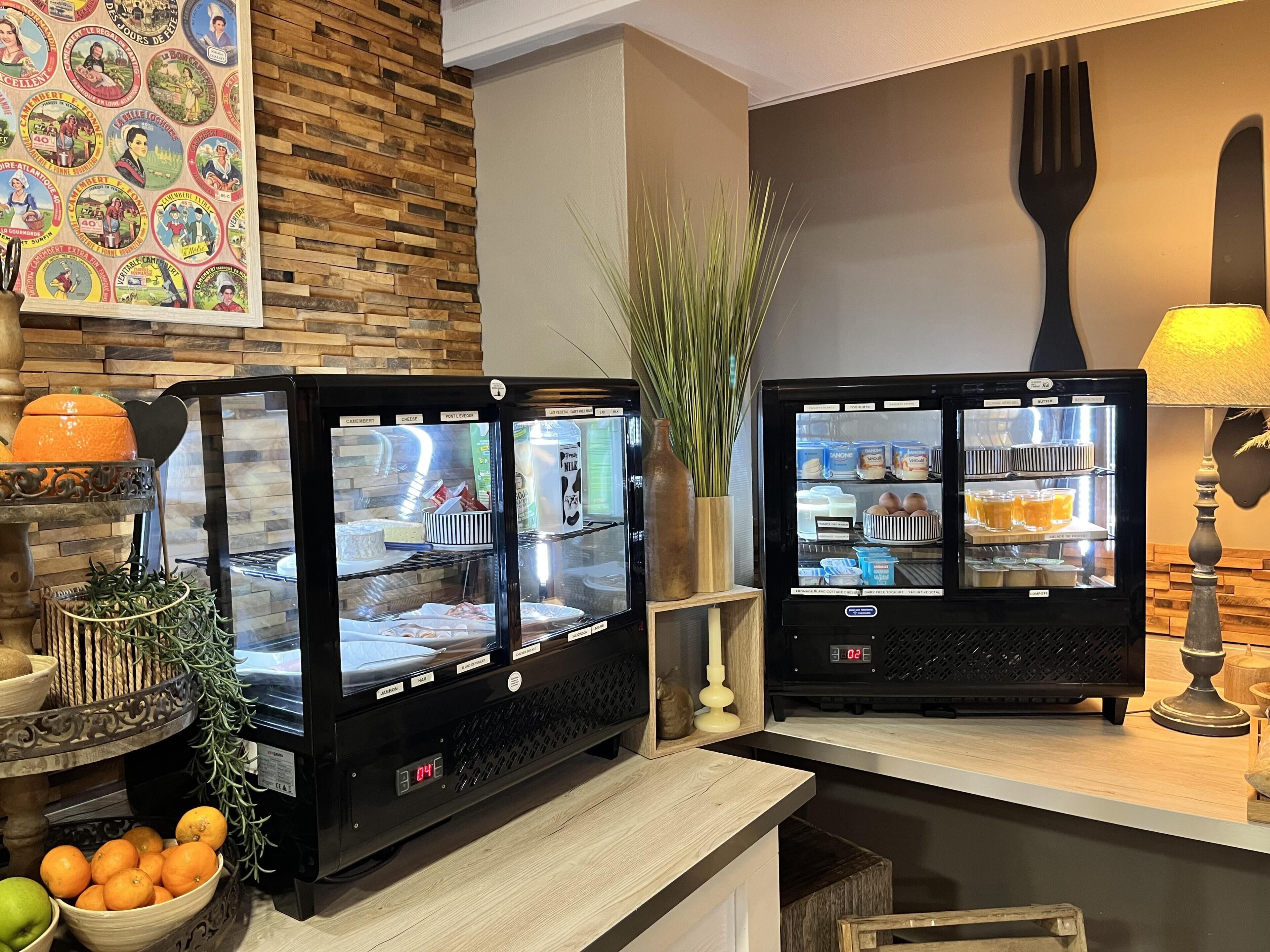 Two self-service beverage dispensers with various drink options, a decorative wall with vintage postcards, and a rustic wooden counter.