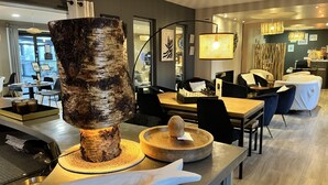 Un comedor moderno con un centro de mesa de madera de abedul, un tablero de ajedrez y mobiliario contemporáneo.