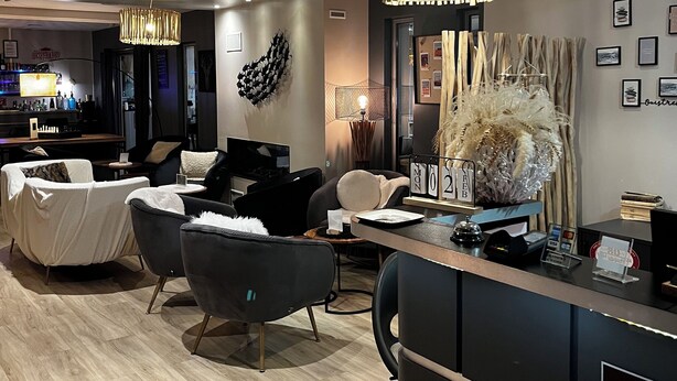A modern hotel lobby with a reception desk, seating area, and a bar. - Best Western La Mare o Poissons (Ouistreham)