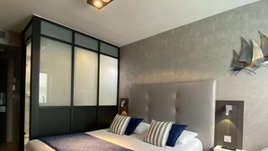 Un dormitorio moderno con una cama grande, cabecera, mesita de noche y lámpara de pared.