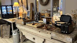 Mostrador de panadería con pan, pasteles y una máquina de café.