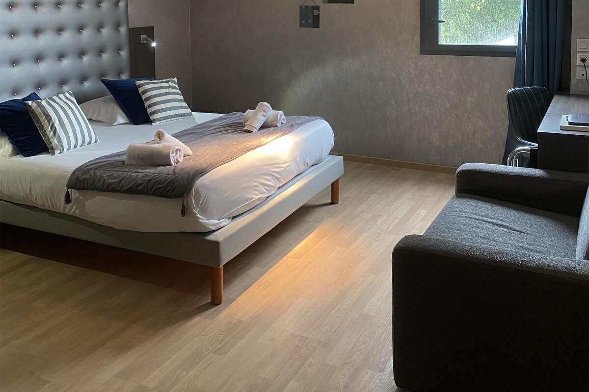 Un dormitorio moderno con una cama, un escritorio y una ventana.