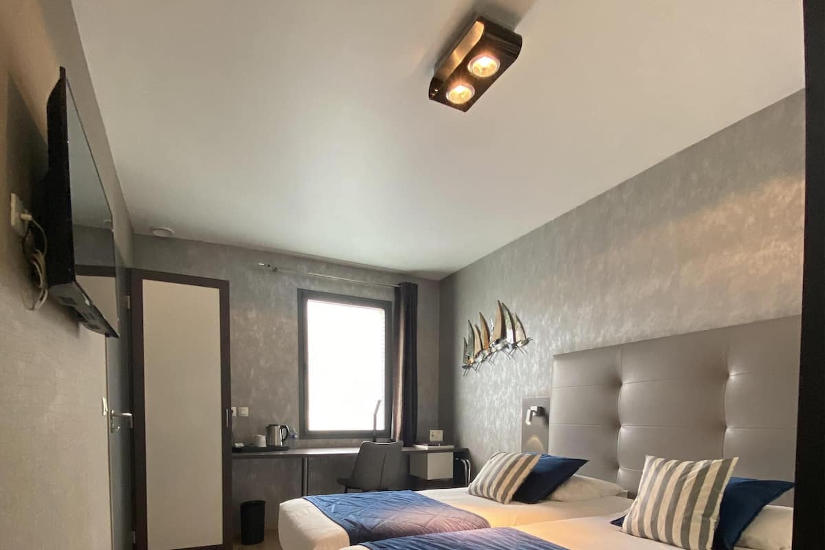 Un dormitorio moderno con una cama grande, un escritorio y una ventana.