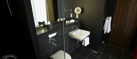 A modern bathroom with a toilet, sink, and mirror.