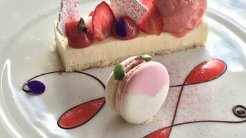 A dessert with ice cream, strawberries, and macarons on a plate.