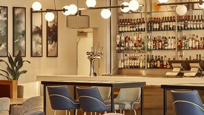 A bar area with seating, a bar counter, and a variety of liquor bottles. - Crowne Plaza Reading by IHG (Reading)