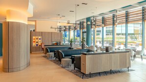 A modern lobby with seating areas, a reception desk, and large windows offering views. - Crowne Plaza Reading by IHG (Reading)