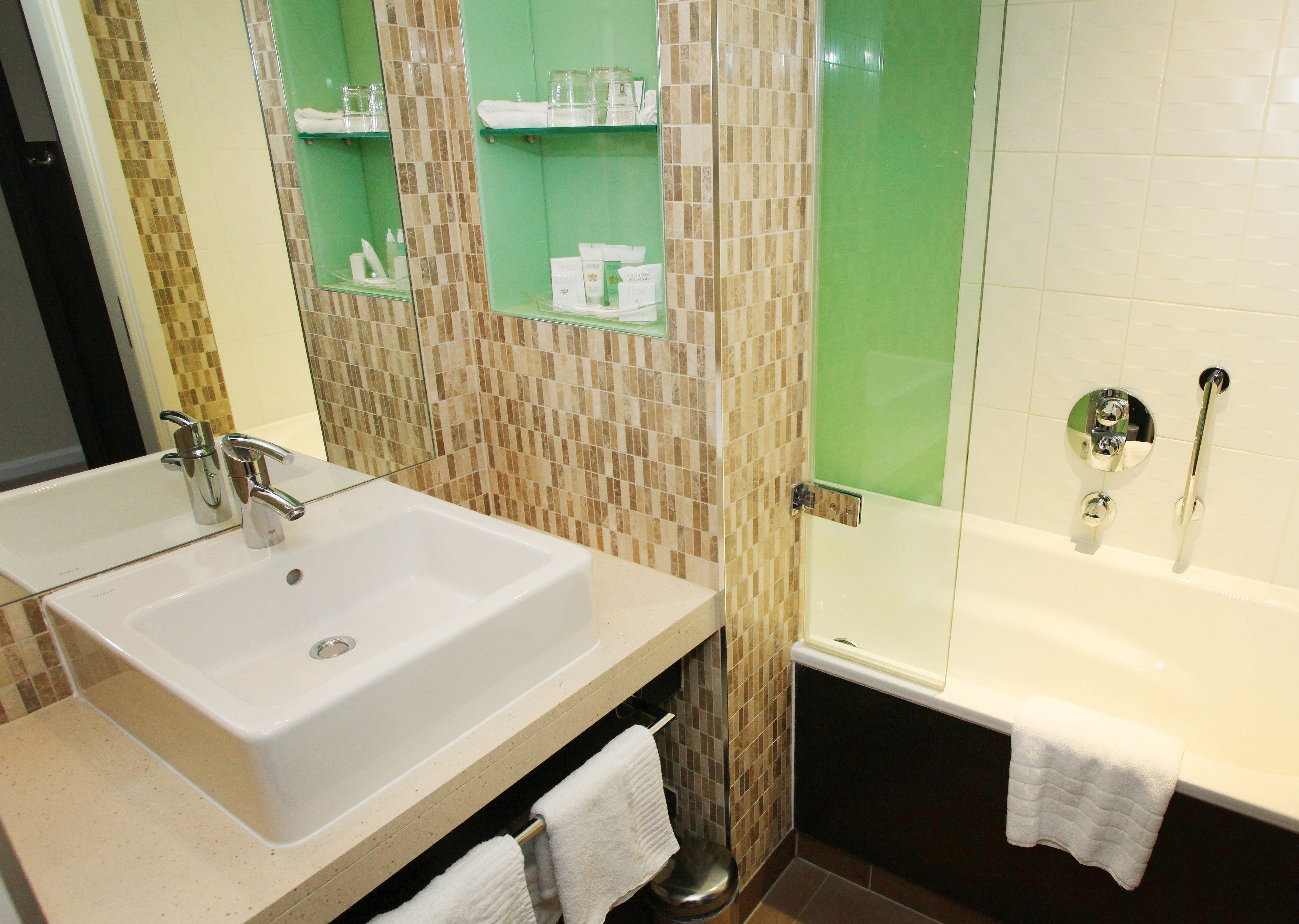 A bathroom with a white sink, a glass shower enclosure, and a bathtub.
