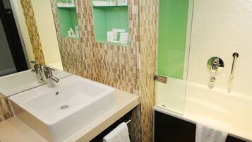 A bathroom with a white sink, a glass shower enclosure, and a bathtub.