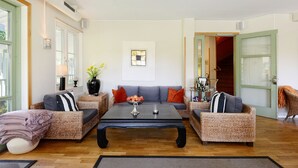 Una sala de estar con un conjunto de sofá, una mesa de centro y un jarrón con flores.