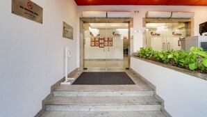 A hotel entrance with a no-smoking sign, a glass door, and a small step leading up to the entrance.