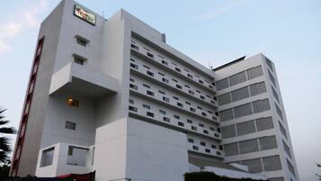 A multi-story hotel with a modern design, featuring a prominent entrance and multiple balconies.