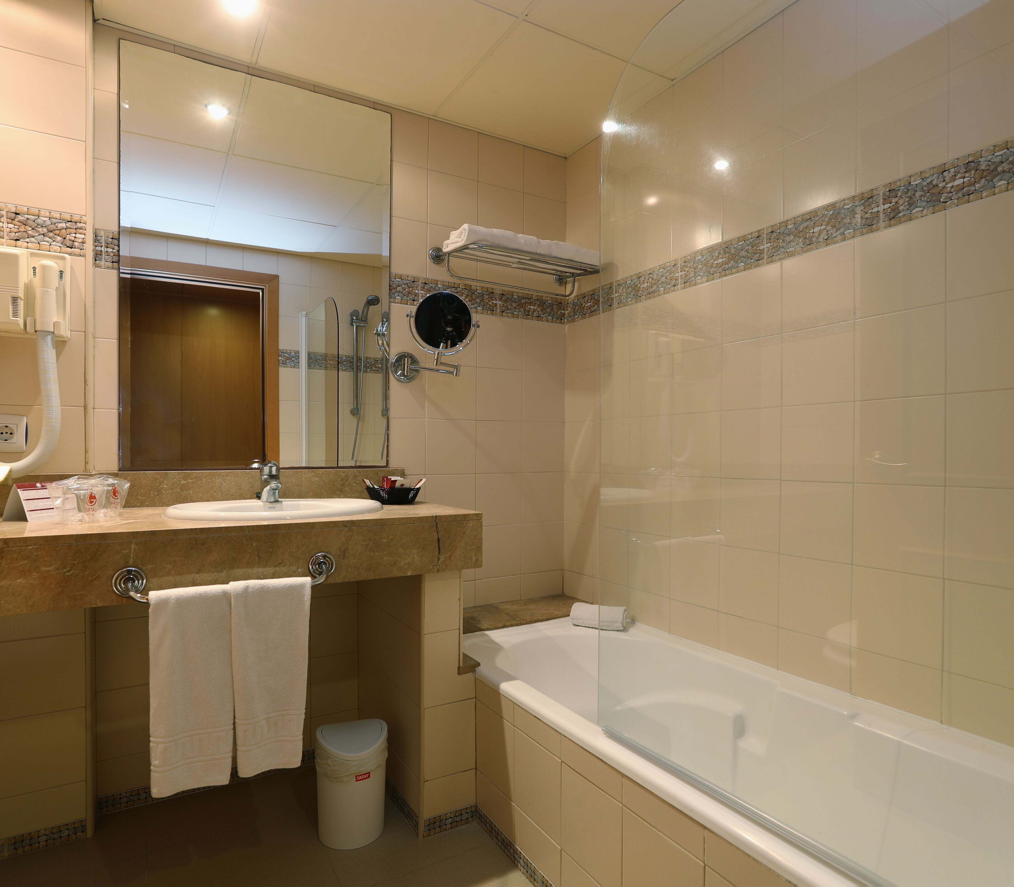 Un baño con lavabo, espejo, toallero, ducha e inodoro.
