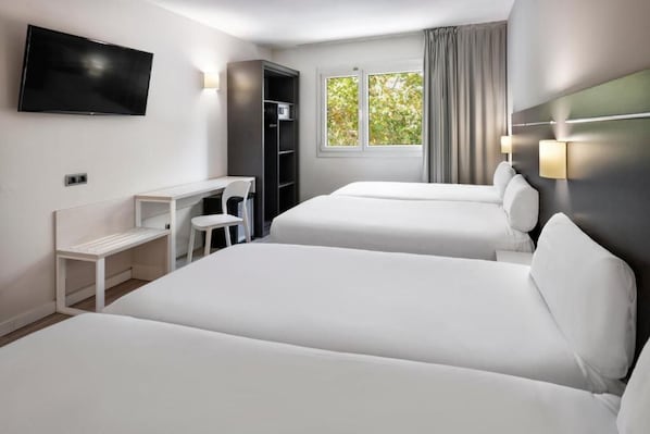 A hotel room with two beds, a desk, a TV, and a window with curtains. - B&B Hotel Barcelona Rubí (Rubi)