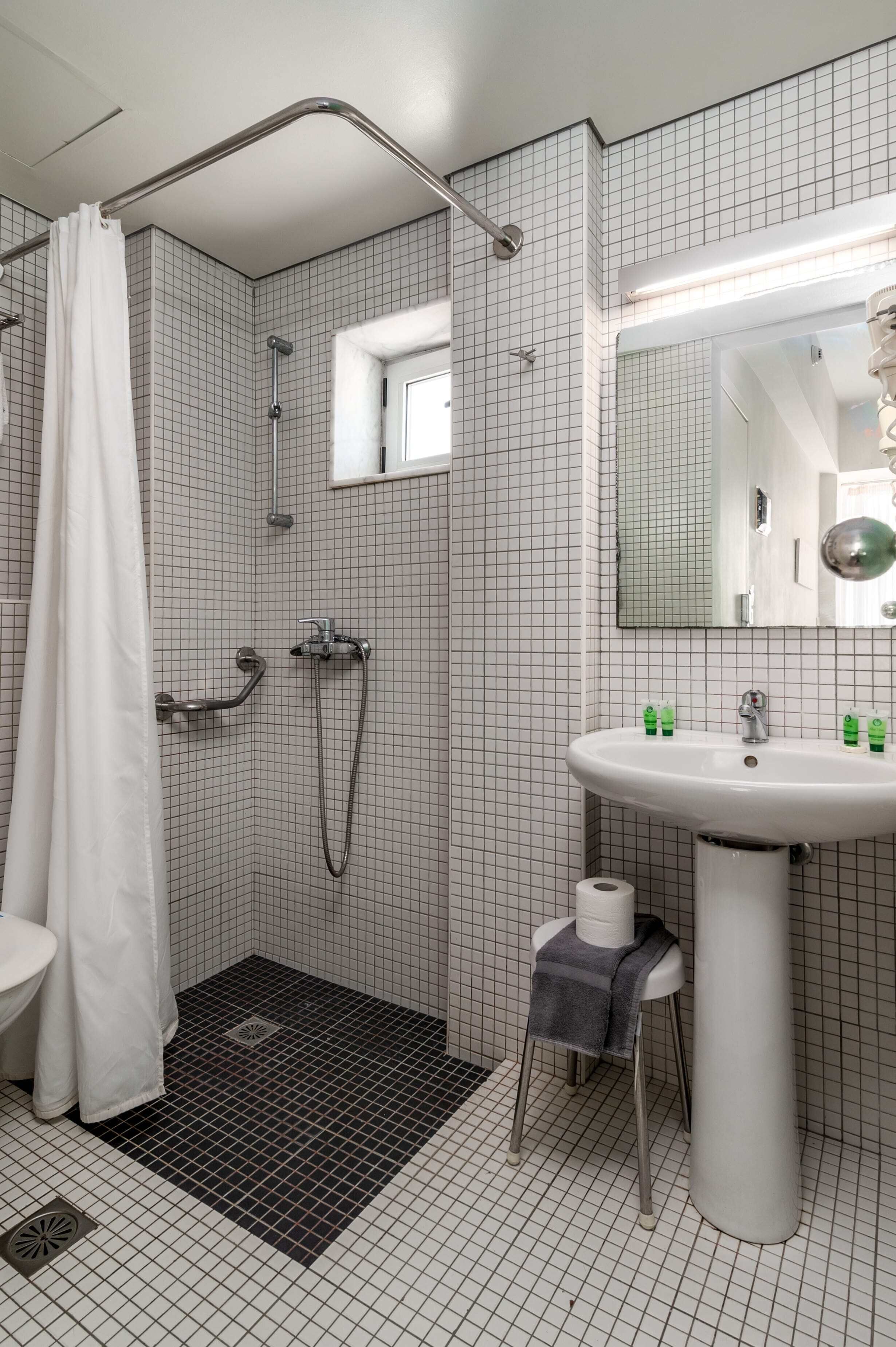 A modern bathroom with a shower, toilet, and sink.
