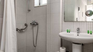 A modern bathroom with a shower, toilet, and sink.
