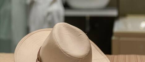 A beige hat with sunglasses on a textured surface.
