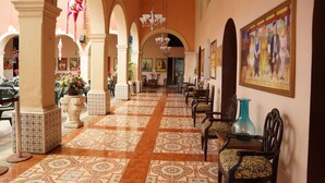 A corridor with patterned flooring, arches, and seating areas. - Hotel Doralba Inn (Mérida)