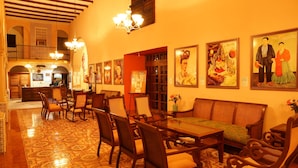 A spacious lobby with a high ceiling, wooden furniture, and traditional artwork on the walls. - Hotel Doralba Inn (Mérida)