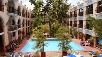 Una piscina al aire libre, sillones reclinables de piscina