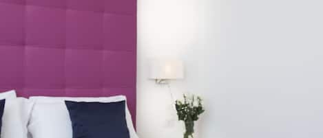 A hotel room with a bed, a nightstand, a lamp, and a decorative elephant figure.